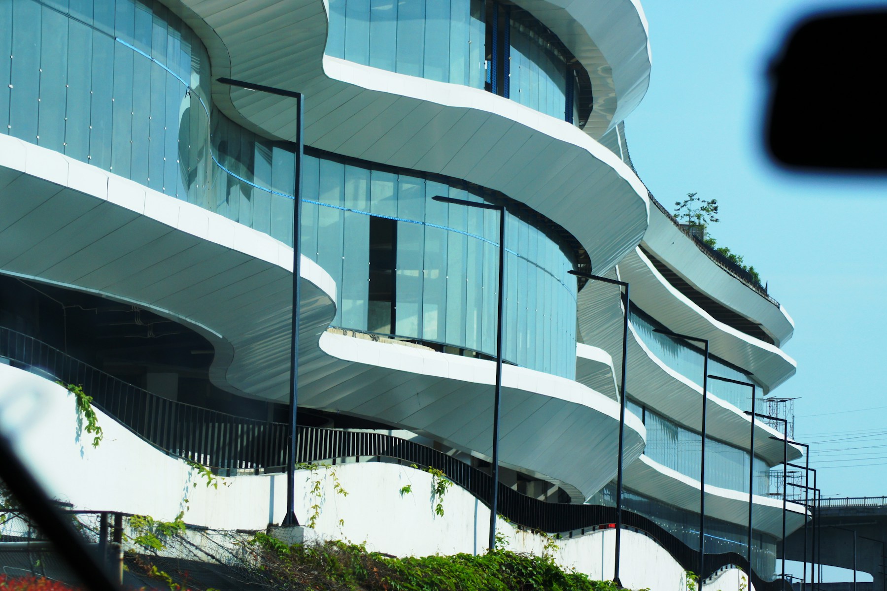 Detalhe de arquitetura contemporânea, com fachada de vidro e linhas curvas